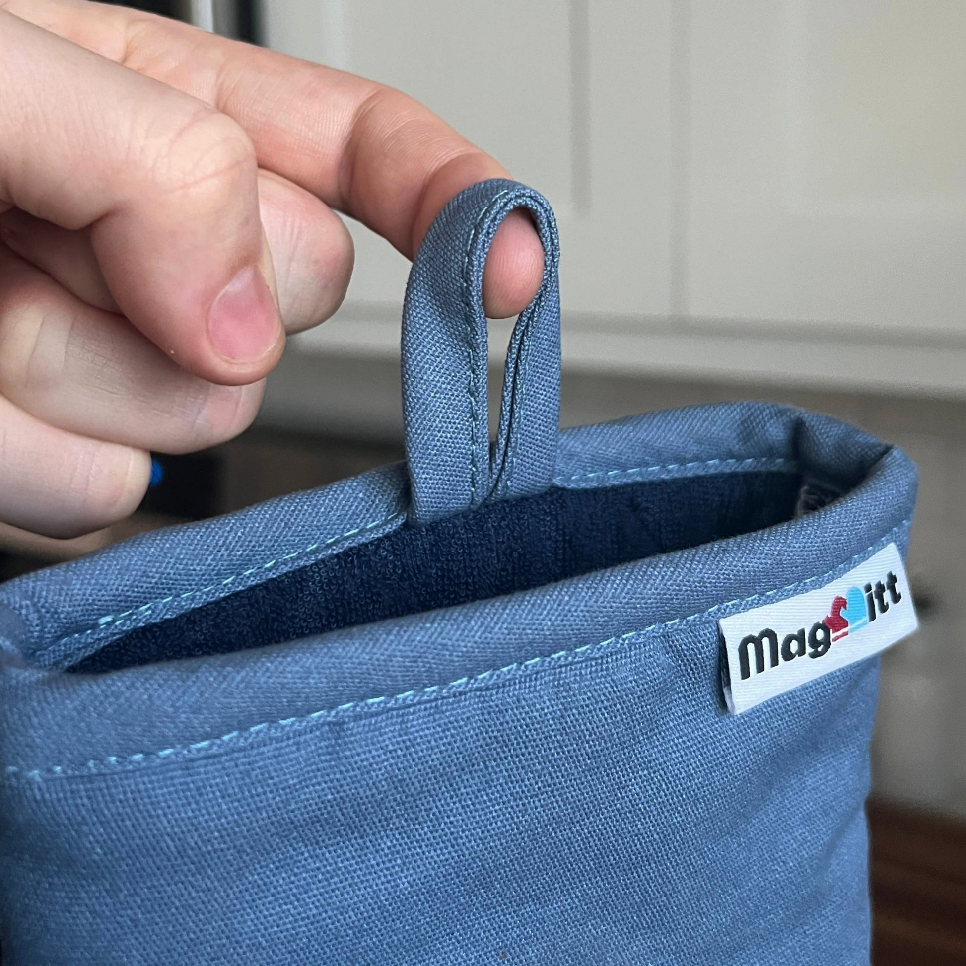 Blue fabric loop with a visible brand logo held by a hand.