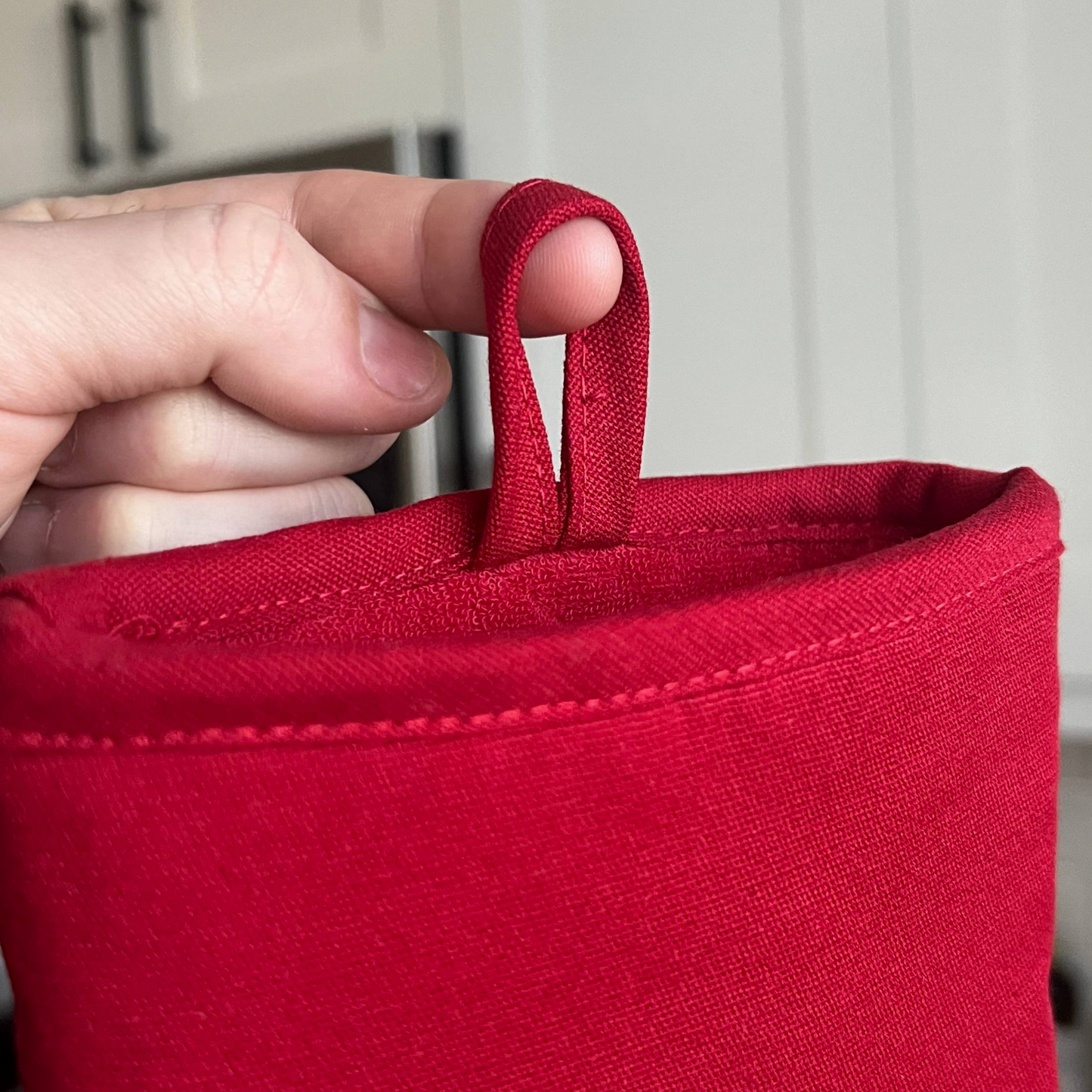 Red fabric LOOP with a hand holding onto it